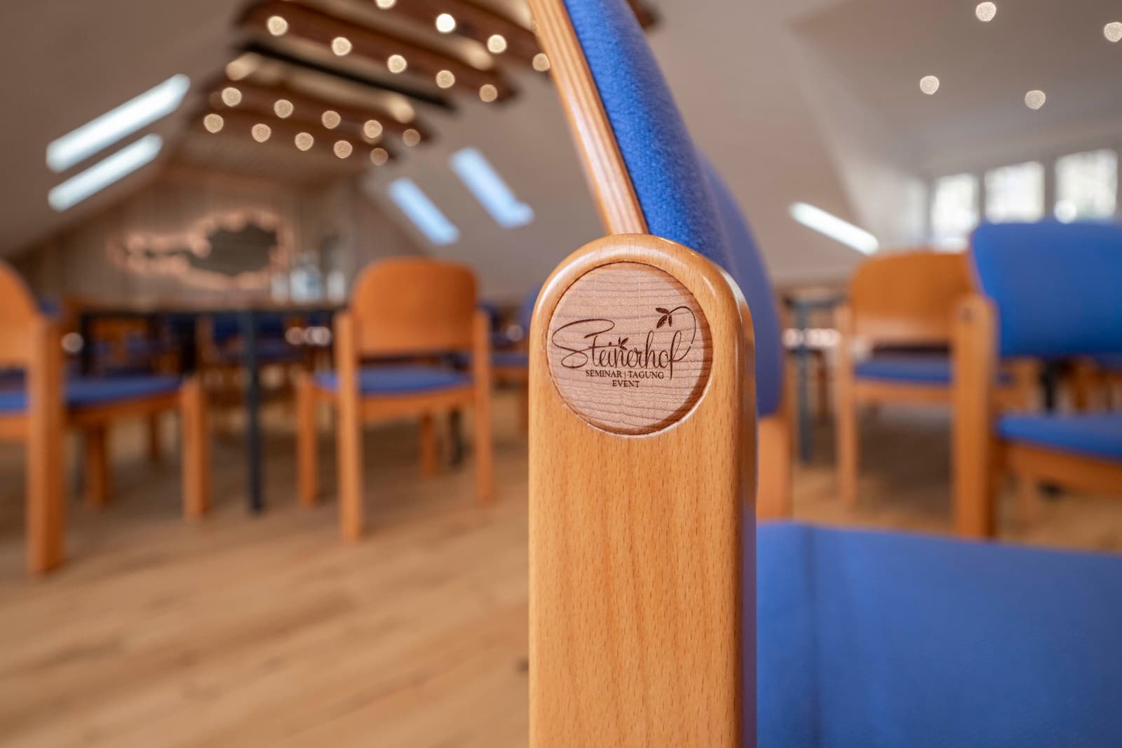 Holzstuhl mit Steinerhof-Emblem